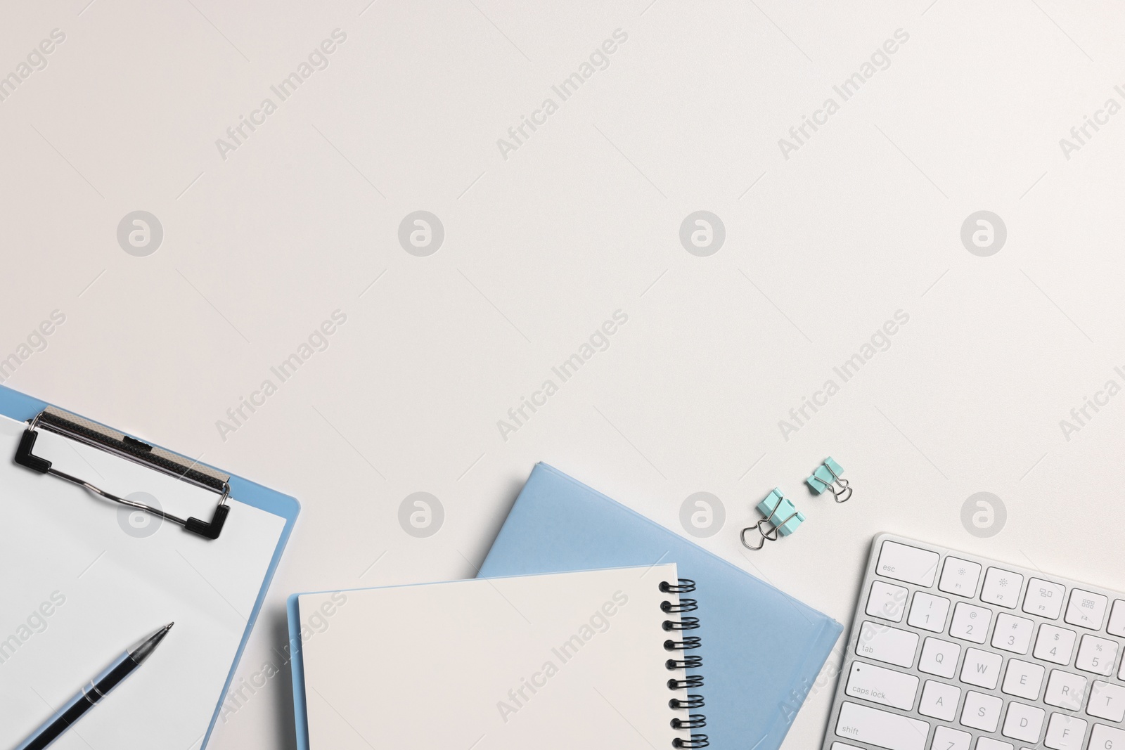 Photo of Flat lay composition with computer keyboard and different stationery on white desk, space for text. Home office