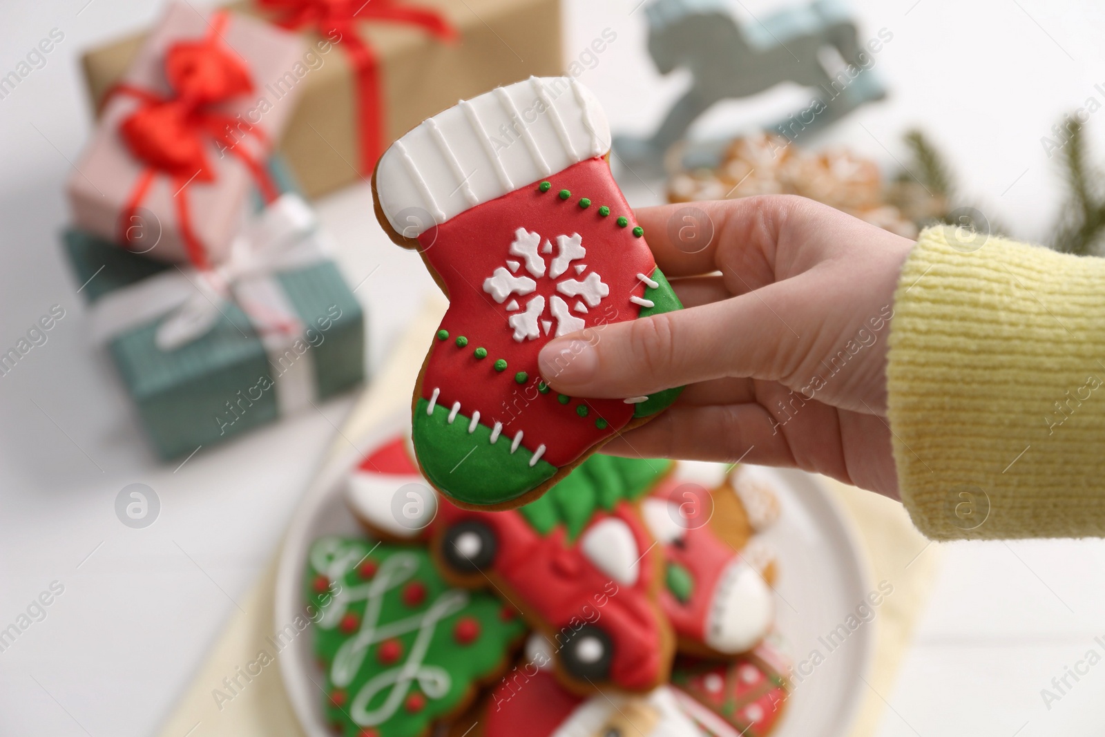 Photo of Woman with decorated Christmas cookie at table, above view