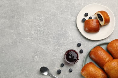 Photo of Delicious baked patties with blueberries on light grey table, flat lay. Space for text