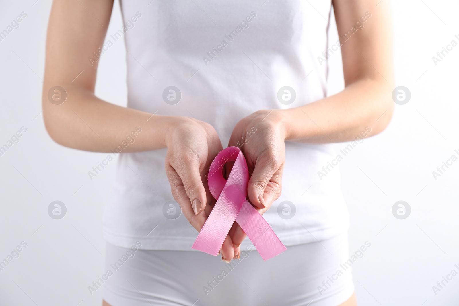 Photo of Young woman with pink ribbon on white background. Gynecology