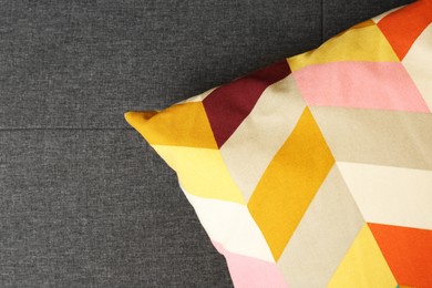 Bright cushion on grey sofa, top view