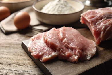 Cooking schnitzel. Raw pork slices on wooden table, closeup