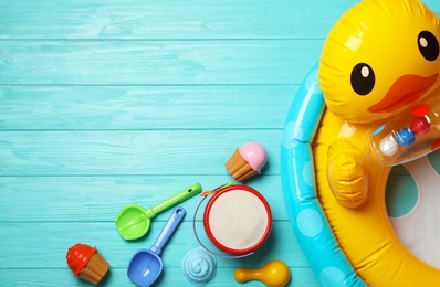 Flat lay composition with beach toys, sand and space for text on wooden background