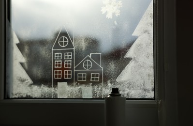 Beautiful drawing made with artificial snow on window. Christmas decor