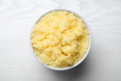 Photo of Bowl of Ghee butter on white wooden table, top view