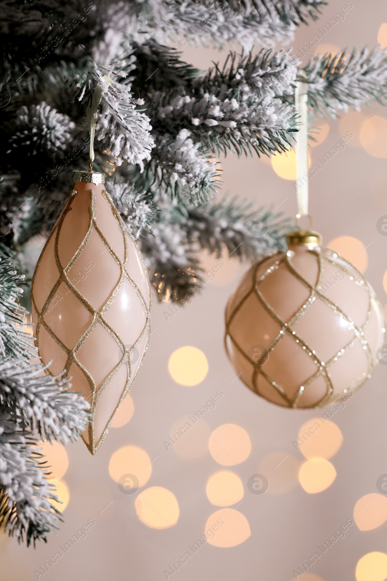 Photo of Christmas tree decorated with holiday baubles against blurred lights, closeup