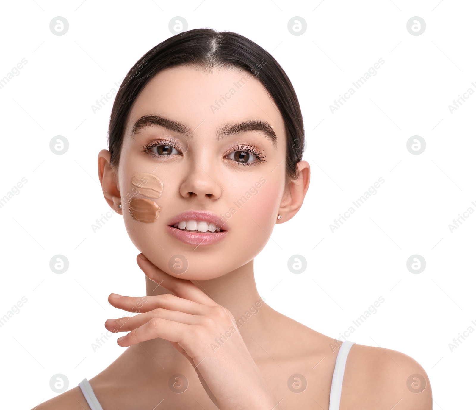 Photo of Teenage girl with swatches of foundation on face against white background