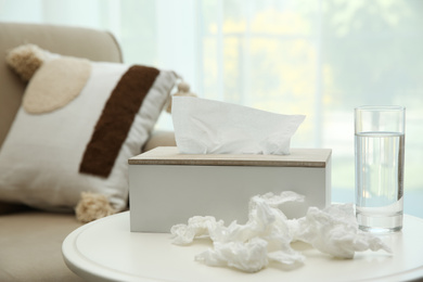 Used paper tissues, holder and water on table indoors