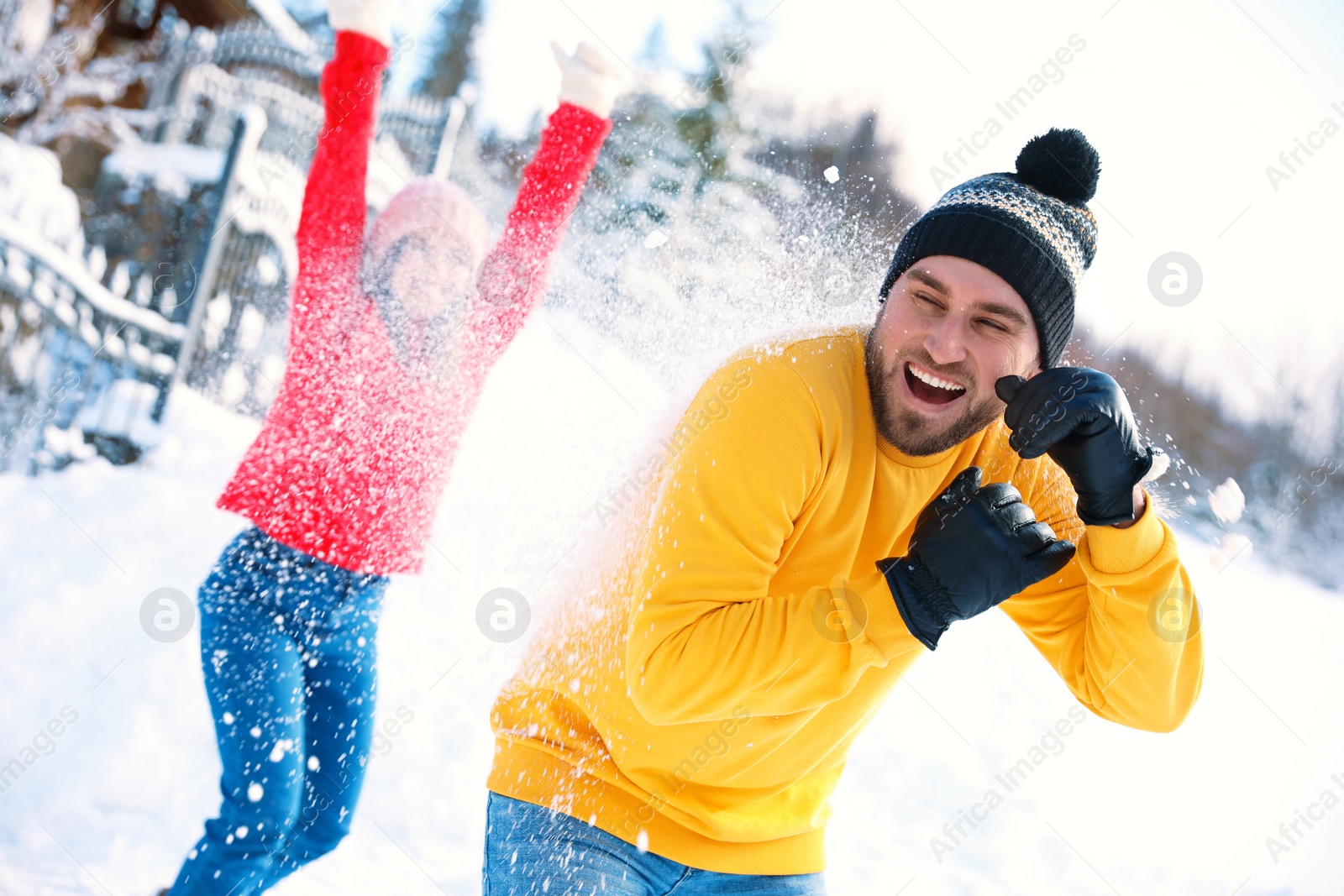 Photo of Happy couple playing snowballs outdoors. Winter vacation