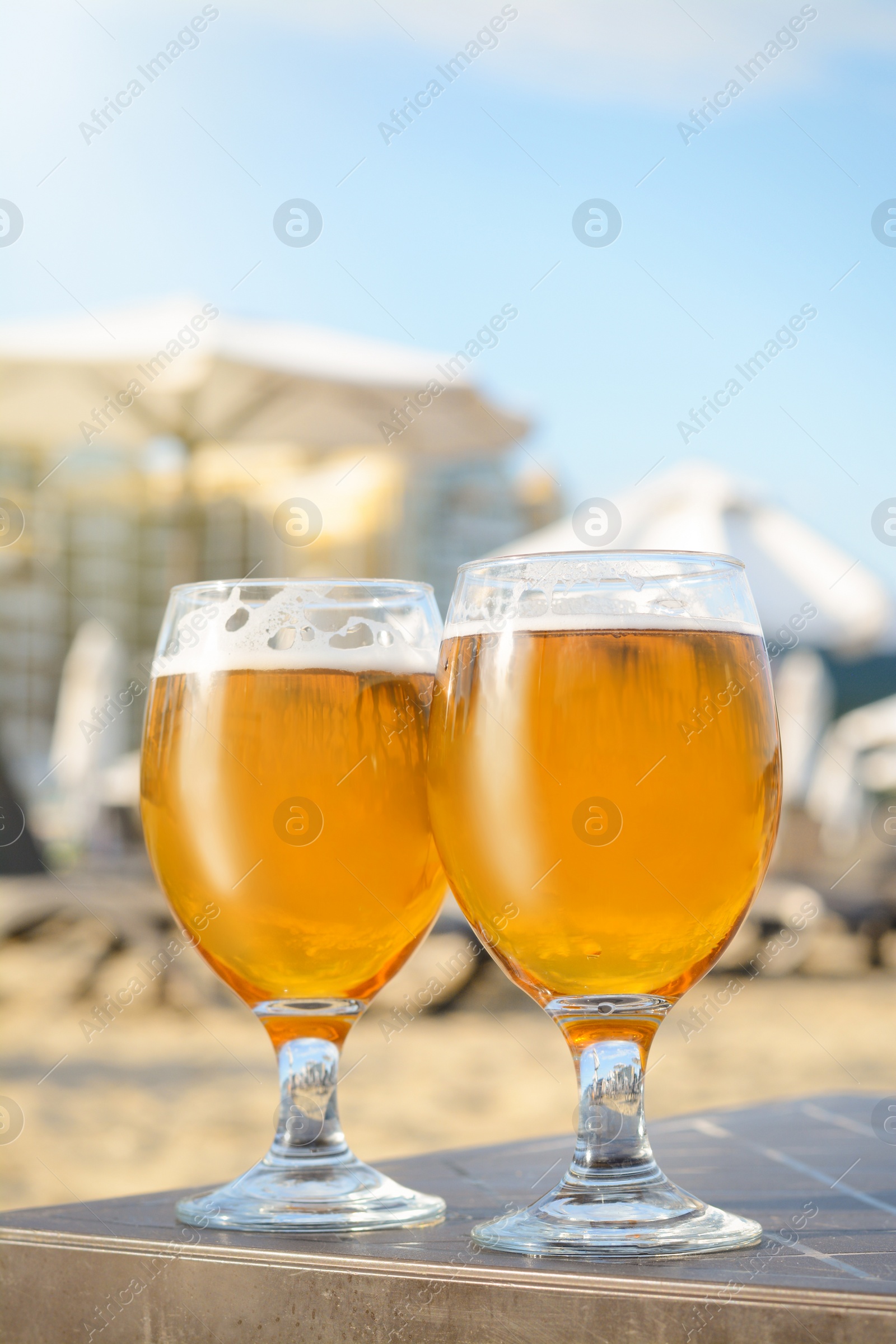 Photo of Cold beer in glass on beach. Space for text