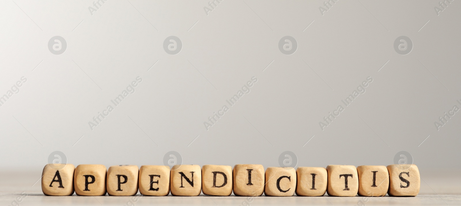 Photo of Word Appendicitis made of wooden cubes with letters on light table
