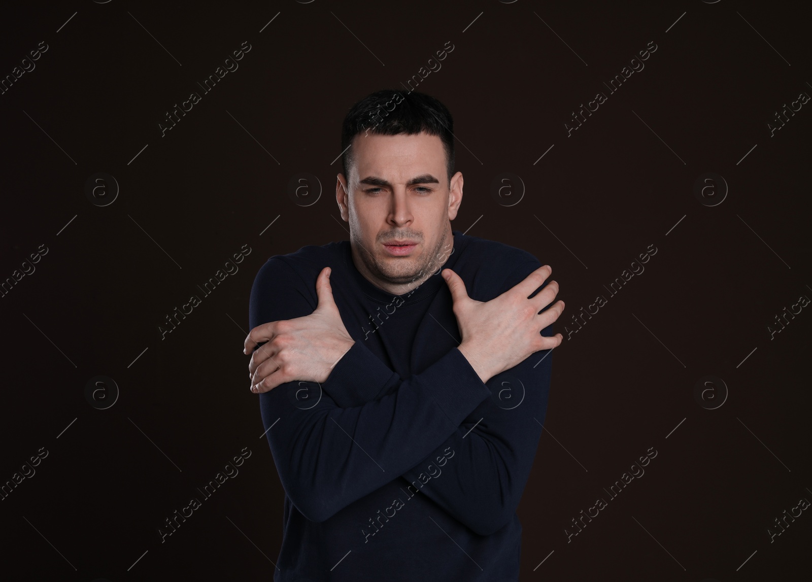 Photo of Young man suffering from fever on dark background. Cold symptoms