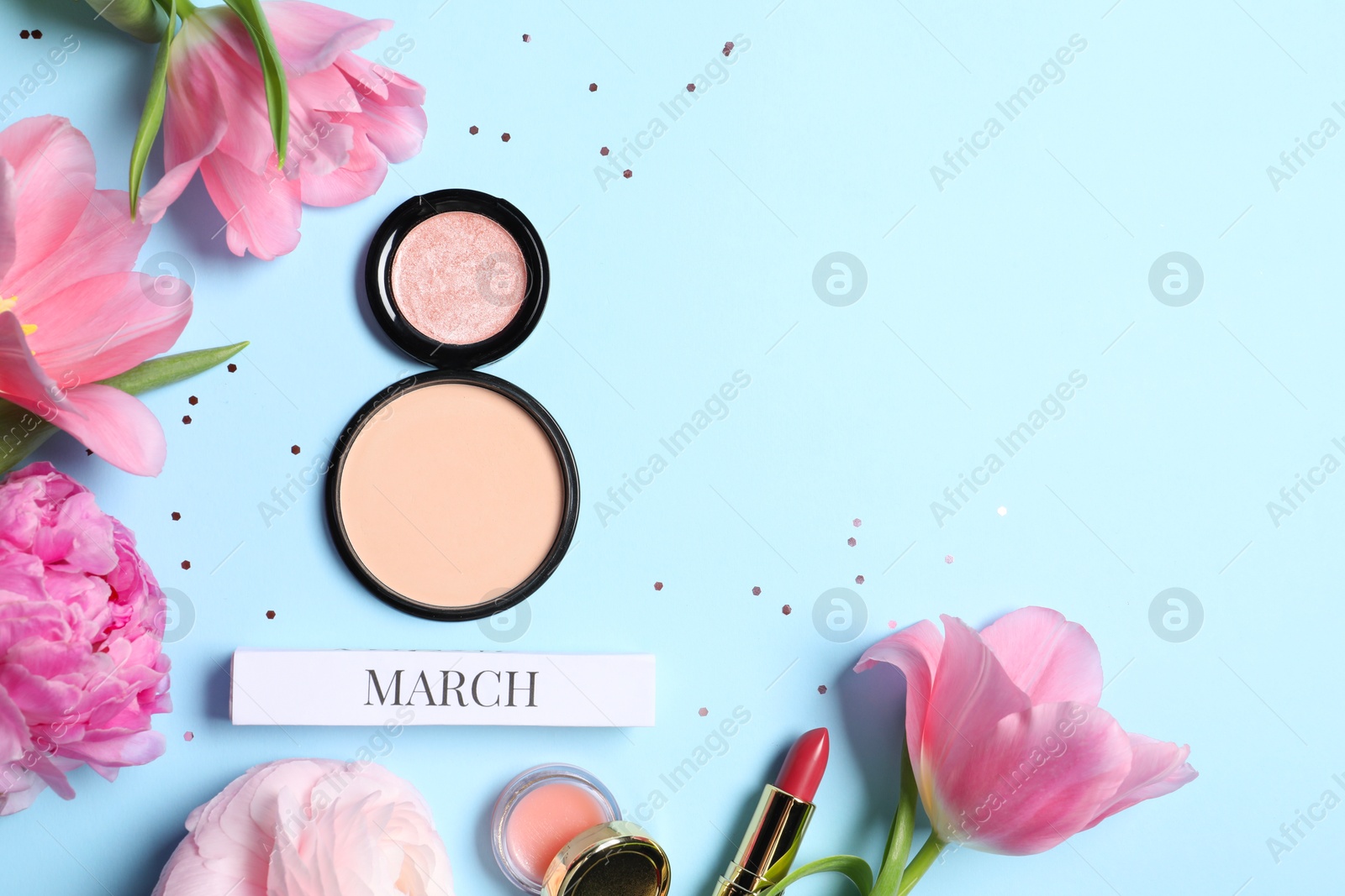 Photo of International Women's day. 8th of March made with powder, makeup products and beautiful flowers on light blue background, flat lay. Space for text