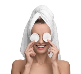 Smiling woman removing makeup with cotton pads on white background