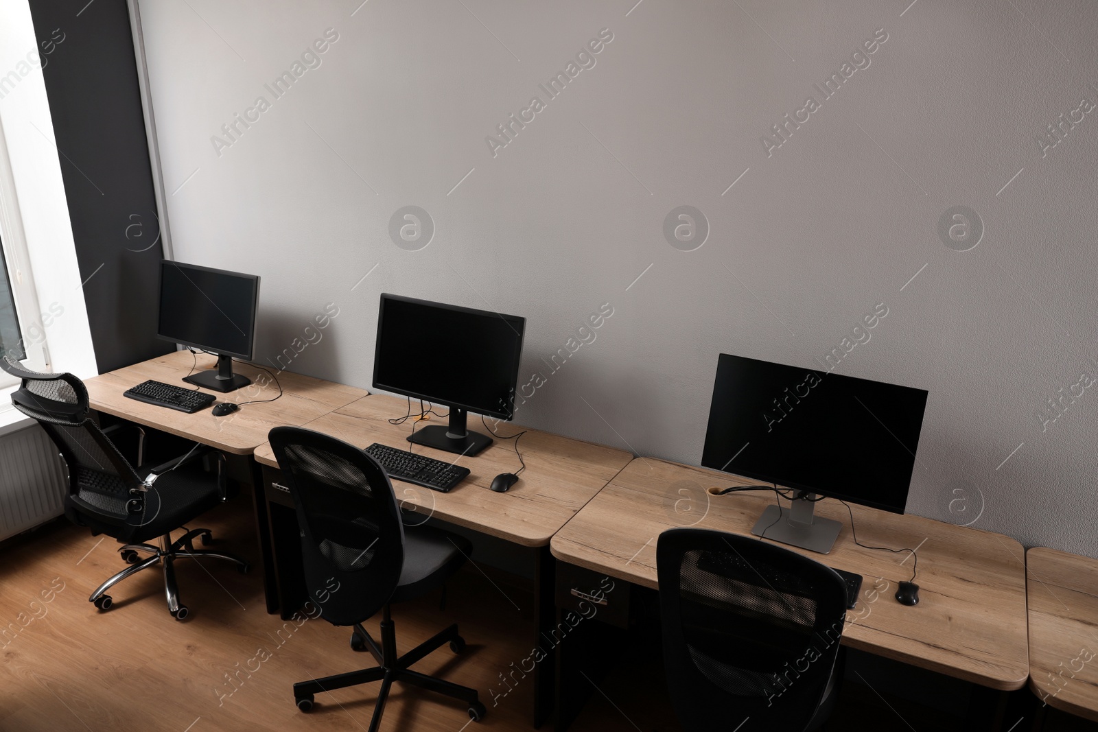 Photo of Row of modern computers in open space office, above view