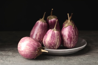 Photo of Ripe purple eggplants on grey table, closeup