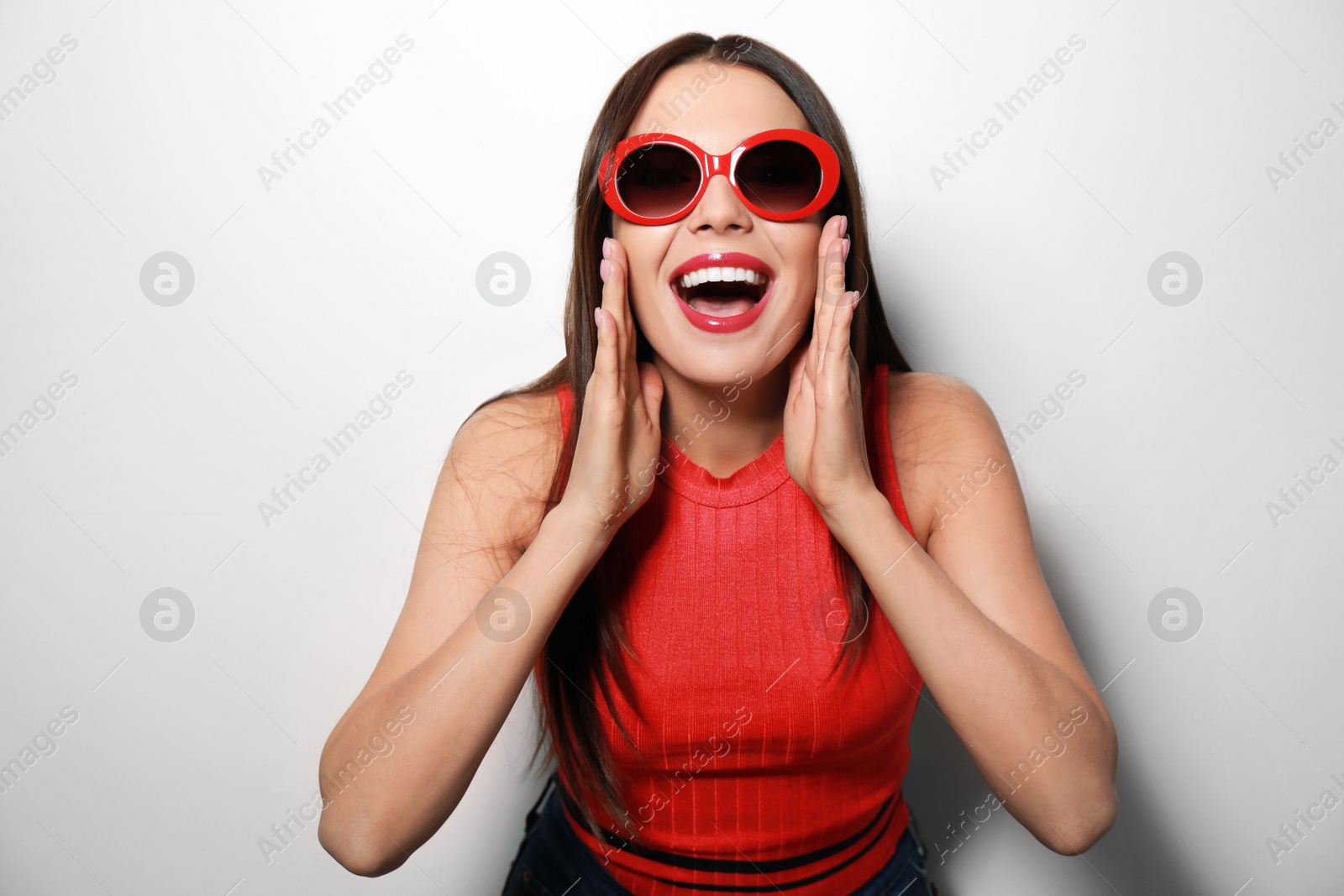 Photo of Beautiful woman in stylish sunglasses on light background