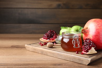 Photo of Honey, pomegranate and apples on wooden table. Rosh Hashana holiday