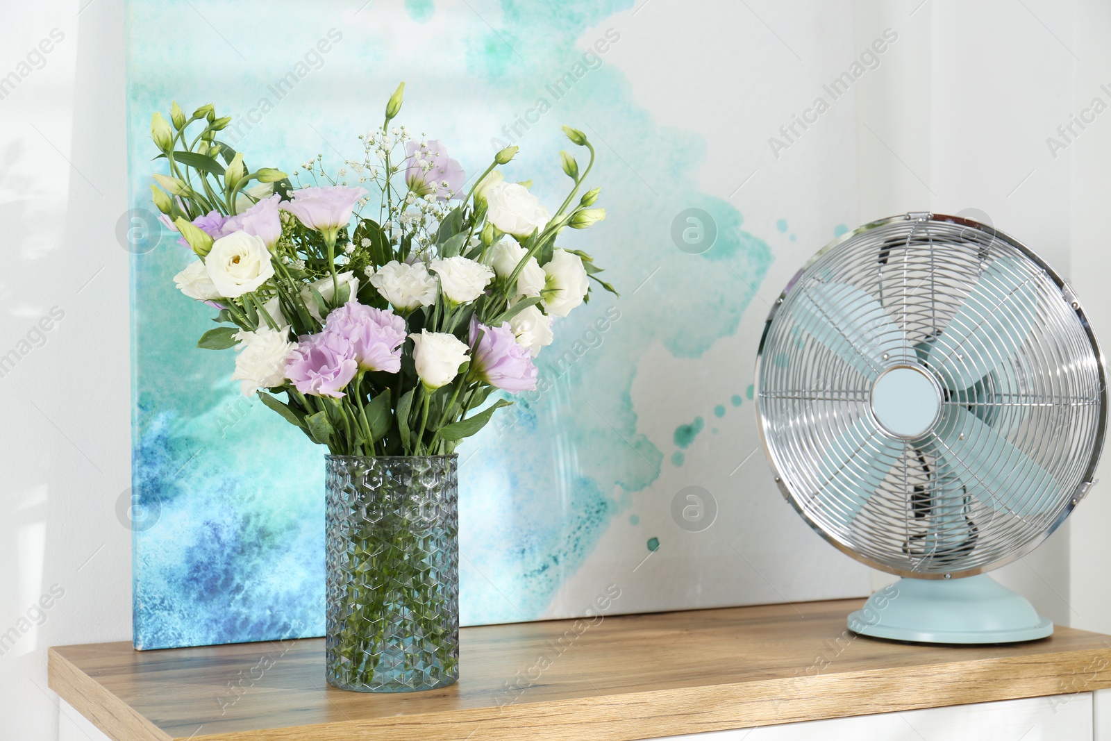 Photo of Bouquet of beautiful Eustoma flowers on table in room