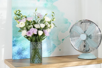 Photo of Bouquet of beautiful Eustoma flowers on table in room