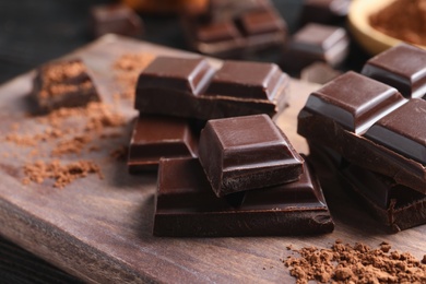 Photo of Pieces of black chocolate on wooden board