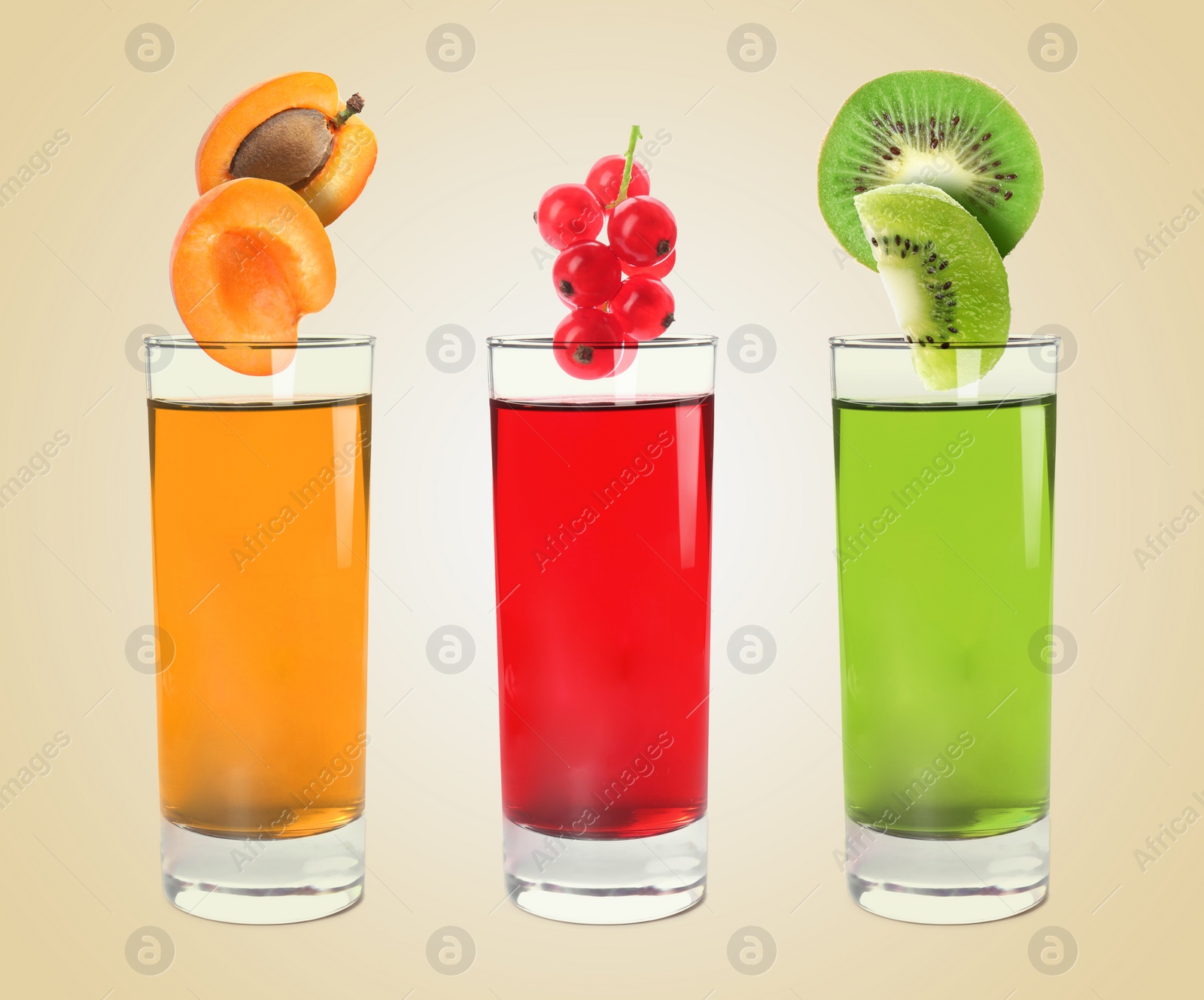 Image of Different freshly made juices on beige background. Fruits falling into glasses