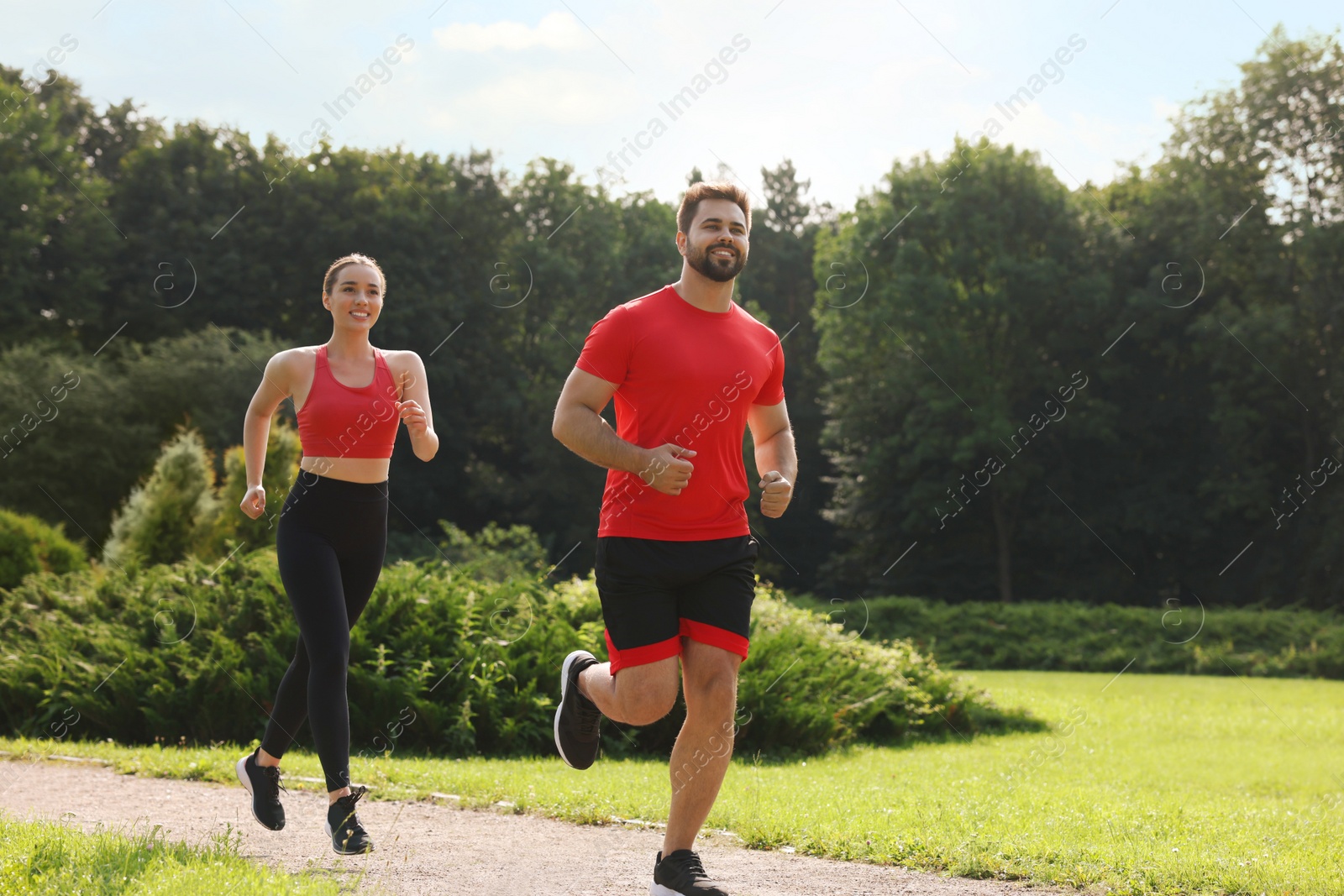 Photo of Healthy lifestyle. Happy couple running outdoors on sunny day, space for text