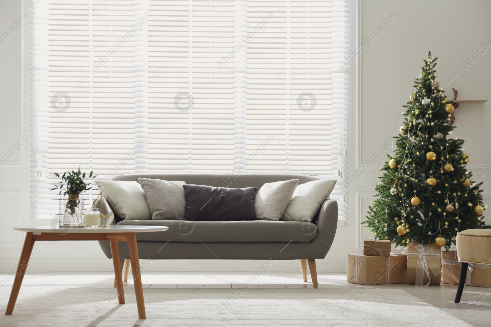 Photo of Beautiful Christmas tree and sofa in contemporary living room. Interior design