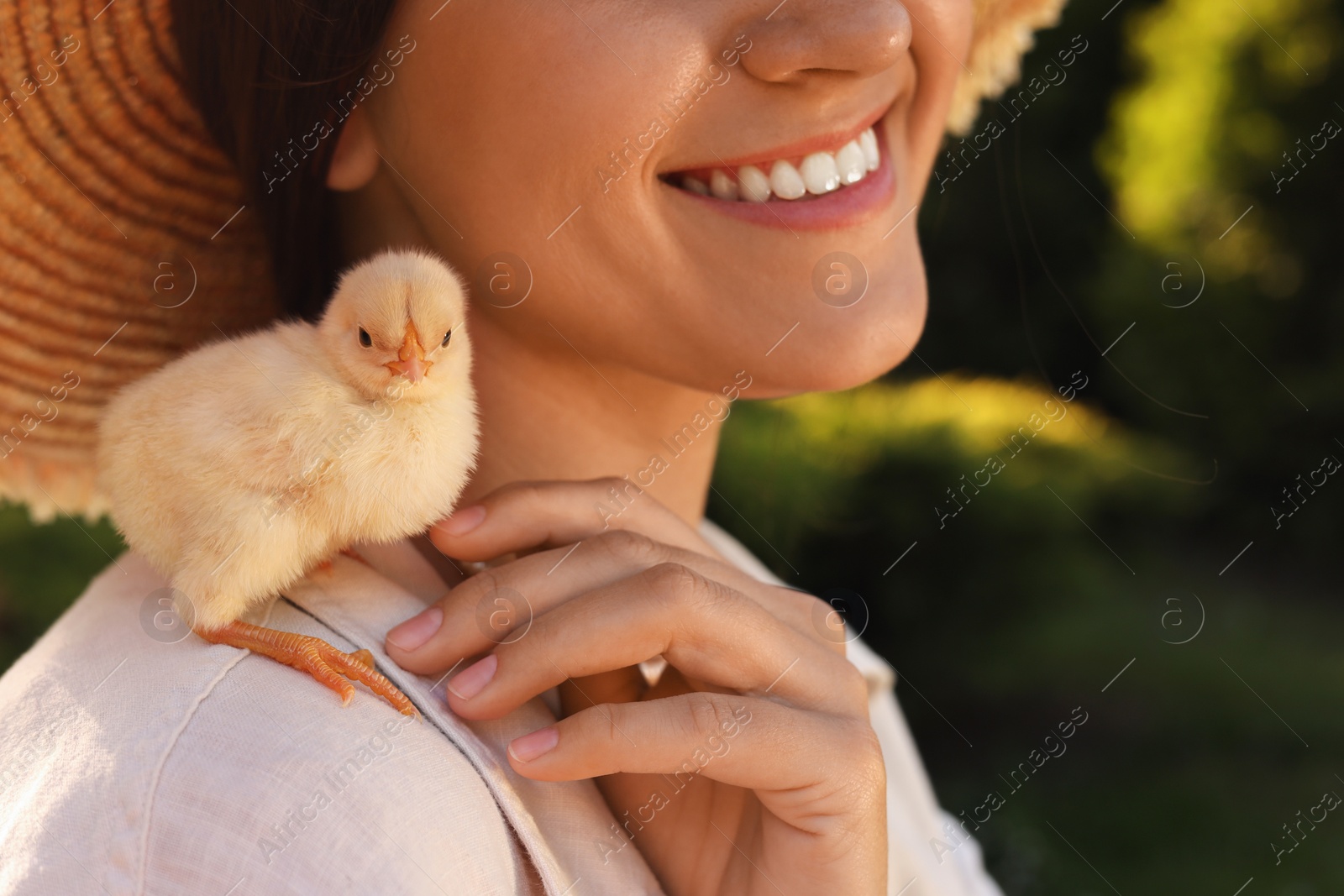 Photo of Woman with cute chick outdoors, closeup. Baby animal