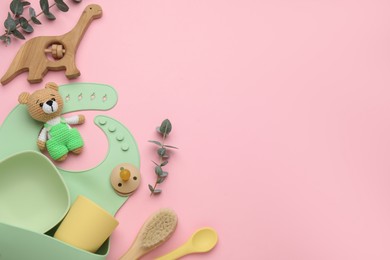 Photo of Flat lay composition with baby accessories and bib on pink background, space for text