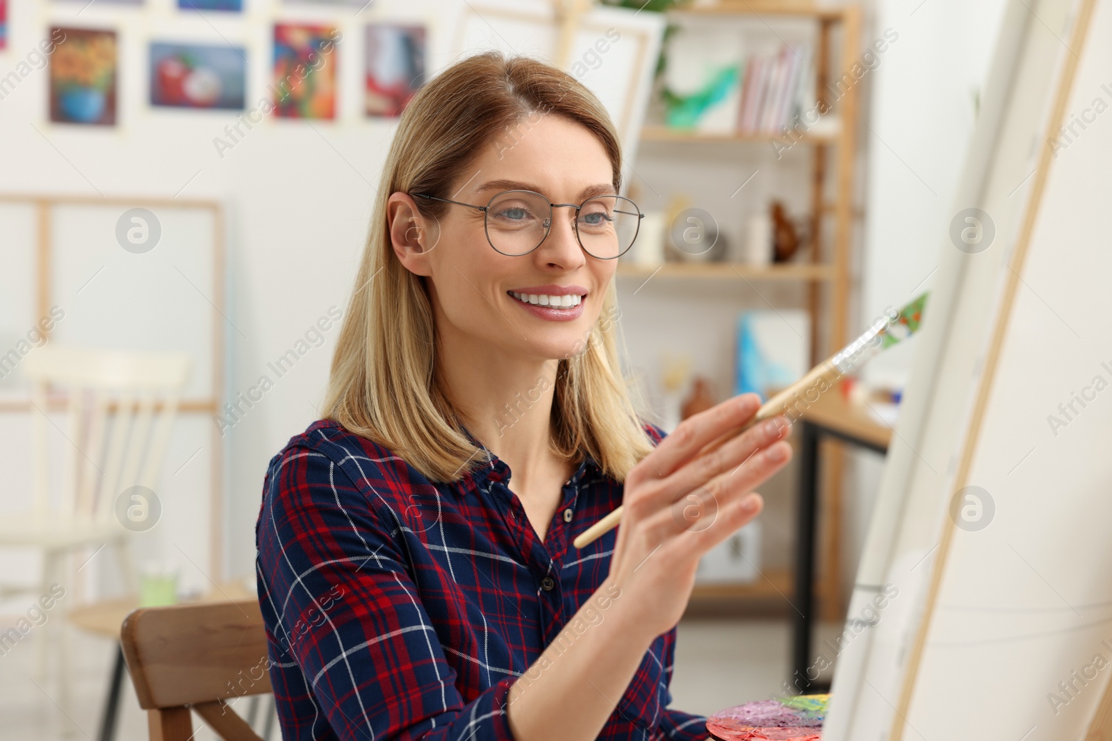 Photo of Woman painting on canvas in studio. Creative hobby