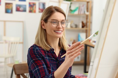 Woman painting on canvas in studio. Creative hobby