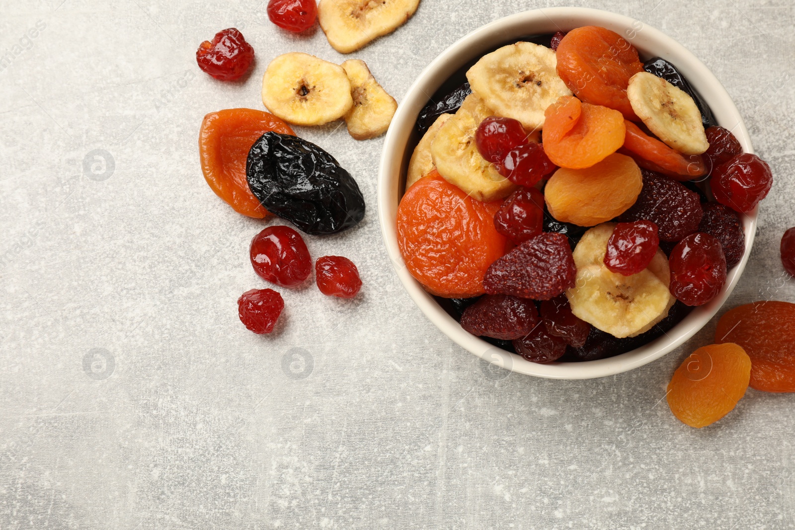 Photo of Mix of delicious dried fruits on grey table, flat lay. Space for text