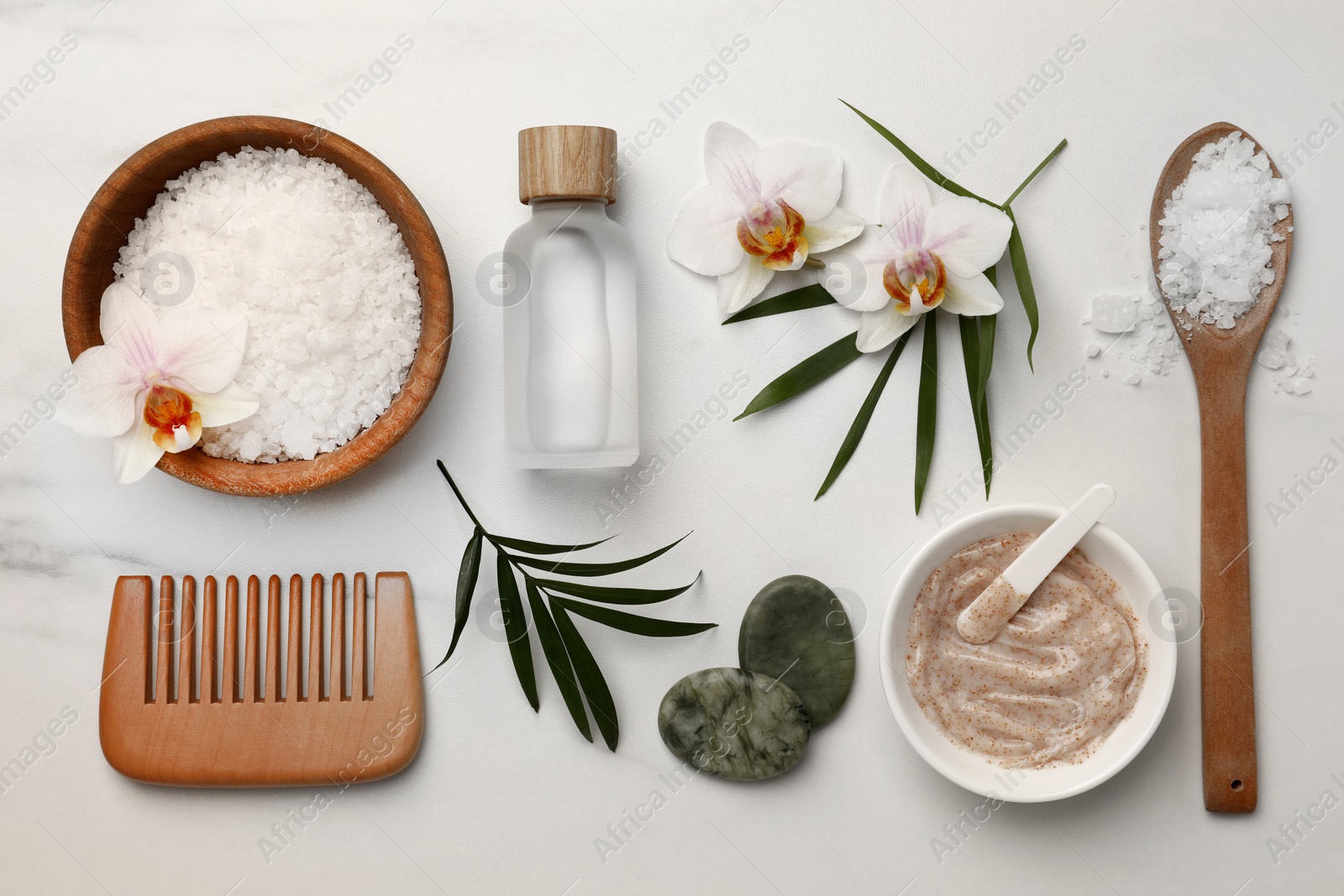 Photo of Flat lay composition with different spa products and flowers on white marble table