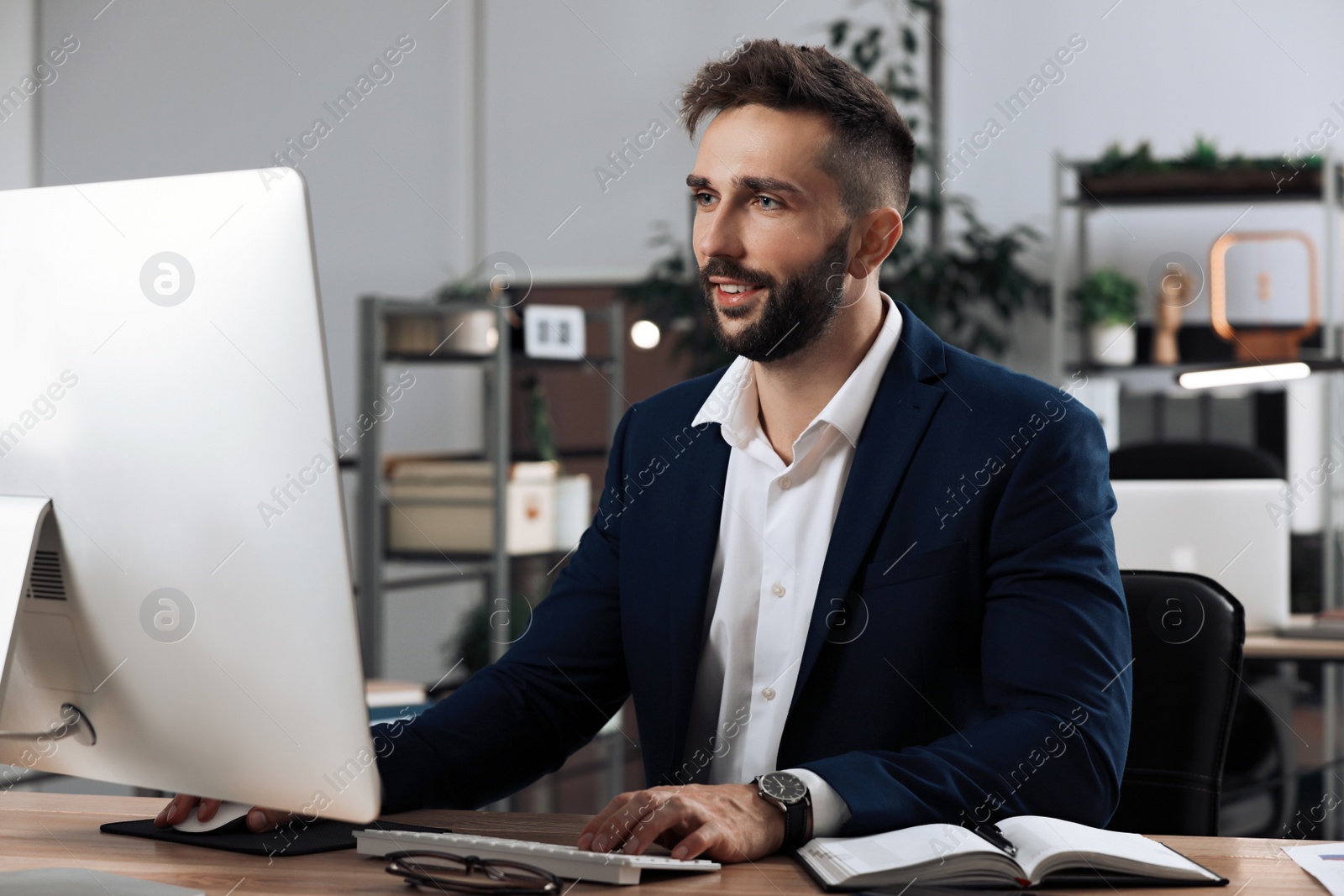 Photo of Man working on computer at table in office