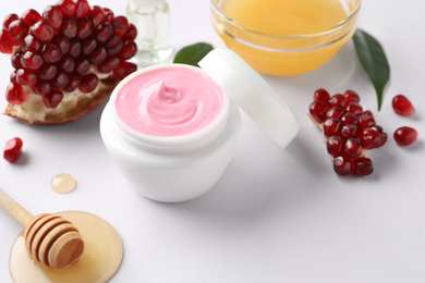 Jar of facial mask, pomegranate and fresh honey on white background. Natural organic cosmetics