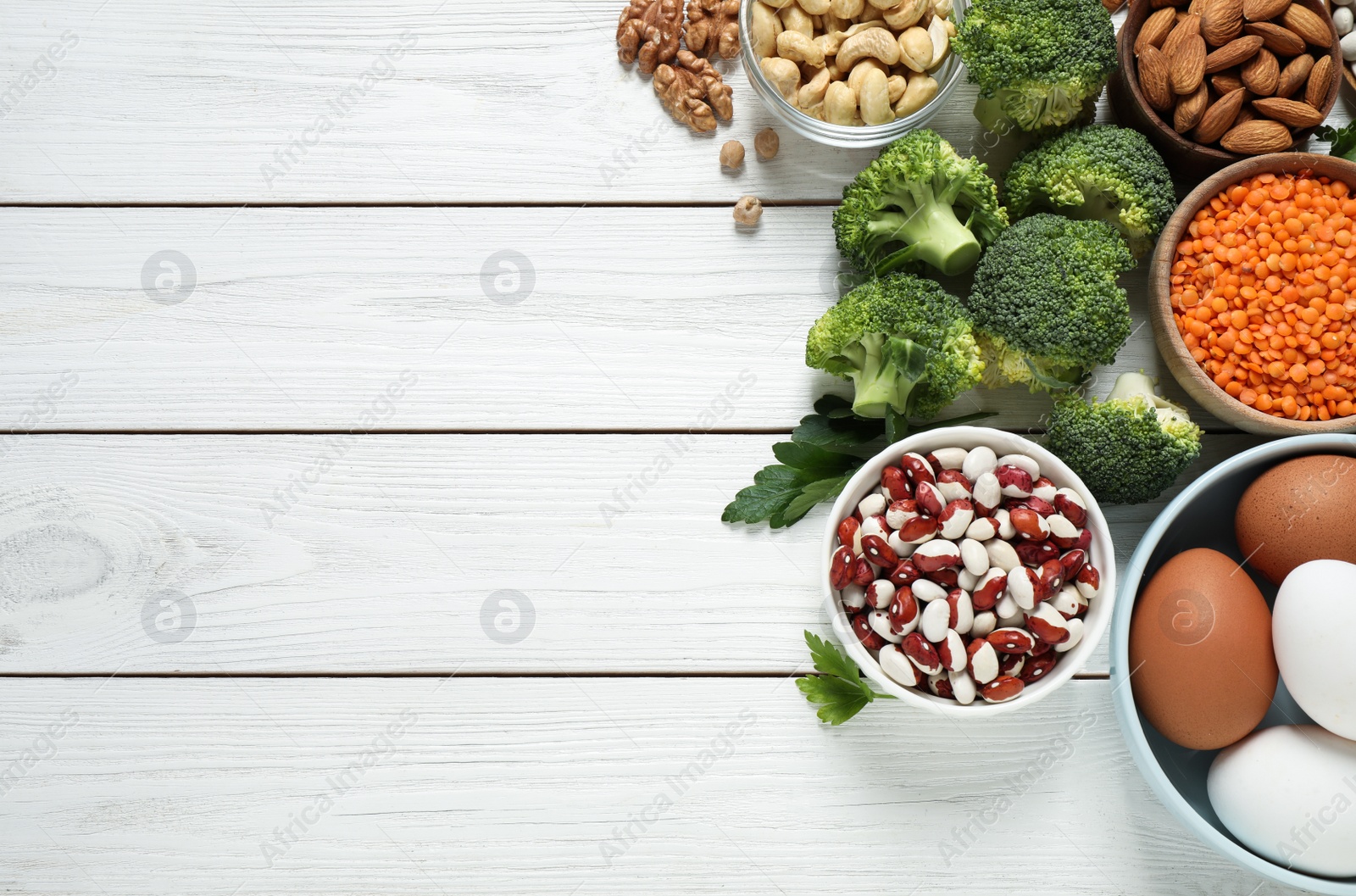 Photo of Products rich in protein on white wooden table, flat lay. Space for text