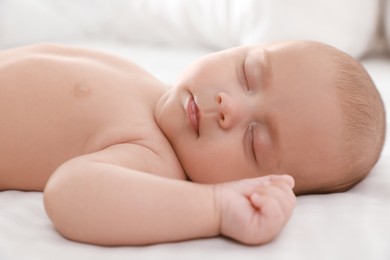 Photo of Cute little baby sleeping on bed, closeup