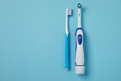 Photo of Electric and plastic toothbrushes on turquoise background, flat lay. Space for text