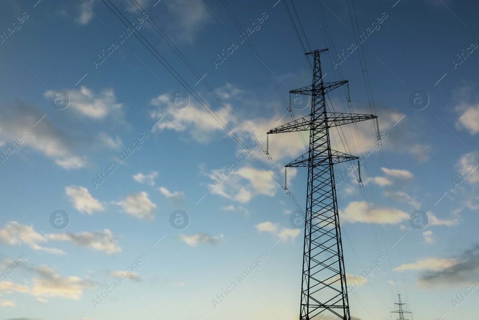 Photo of Telephone pole with cables under blue sky outdoors