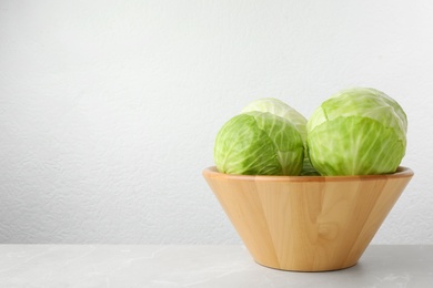 Photo of Ripe white cabbage on light marble table. Space for text