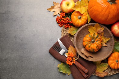 Photo of Flat lay composition with tableware, autumn leaves and vegetables on grey background, space for text. Thanksgiving Day