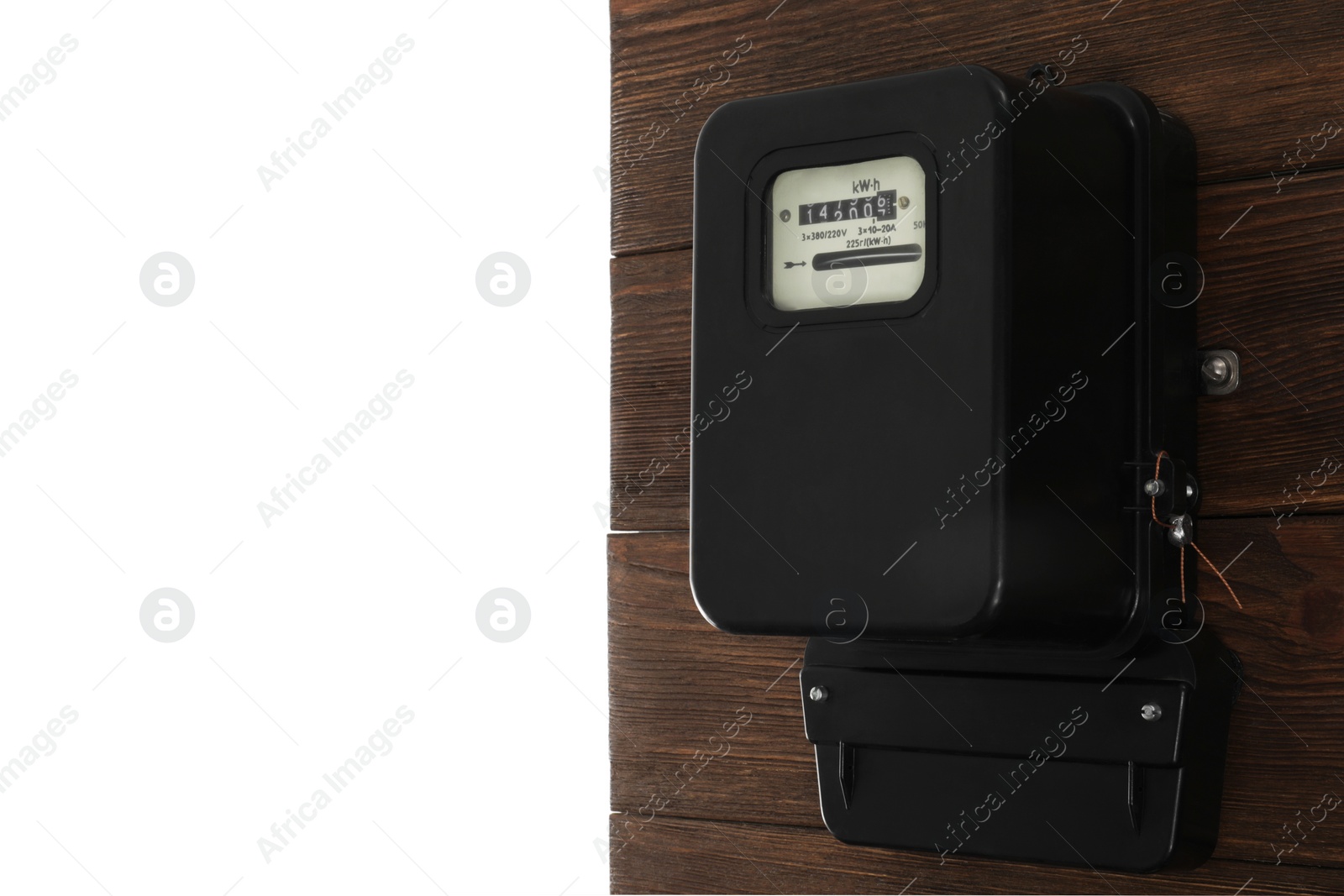 Photo of Electricity meter on wooden wall against white background. Space for text