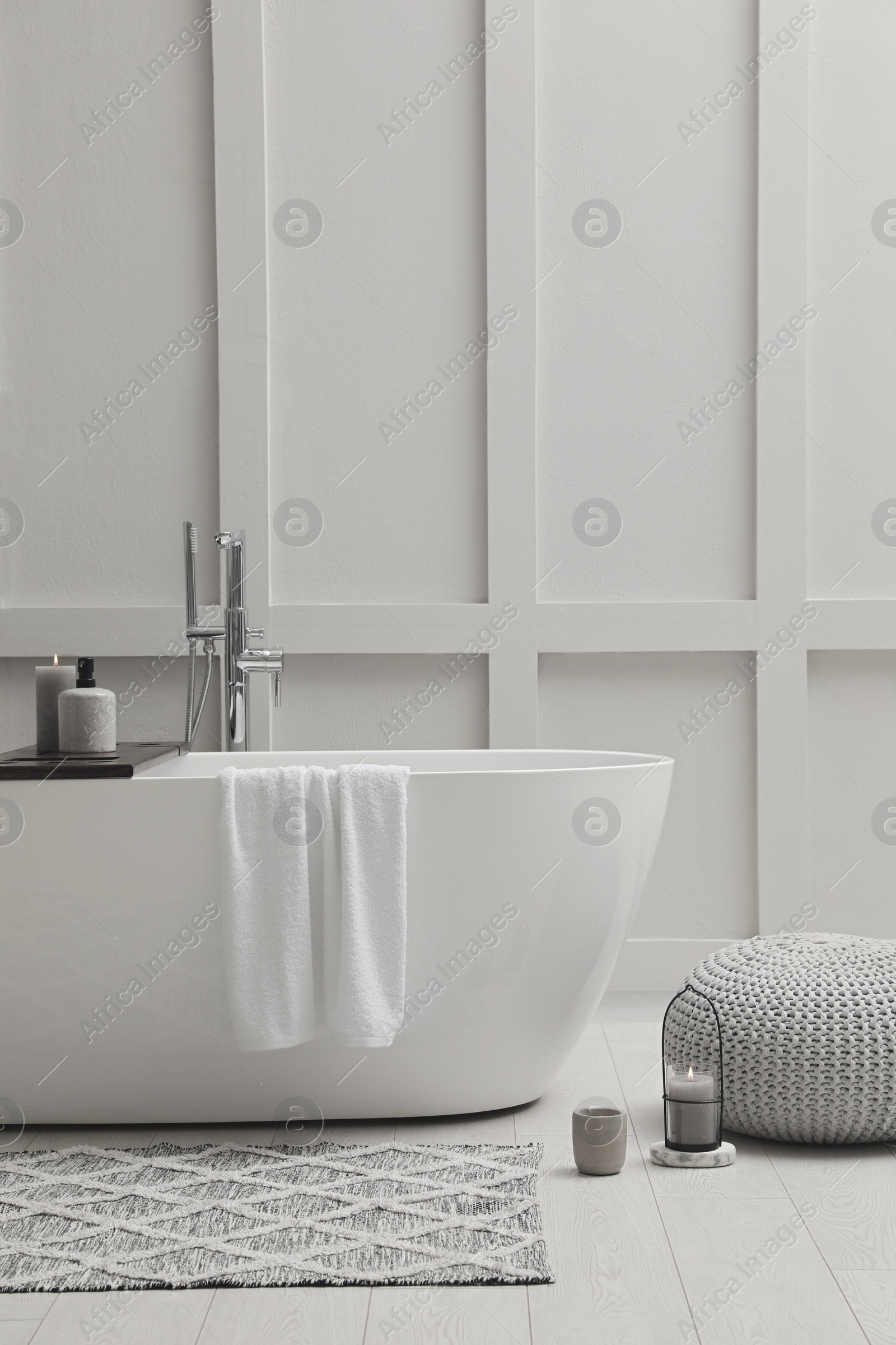 Photo of Modern ceramic bathtub near white wall indoors