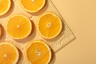 Slices of juicy orange and water on beige background, flat lay. Space for text