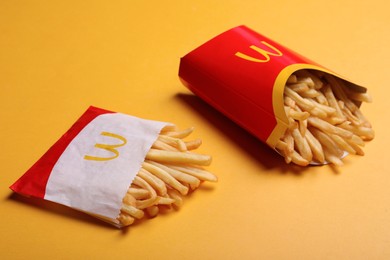 Photo of MYKOLAIV, UKRAINE - AUGUST 12, 2021: Small and big portions of McDonald's French fries on orange background