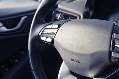 Photo of Black steering wheel inside of modern car, closeup