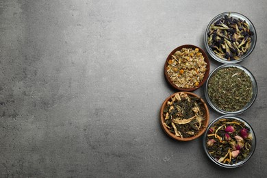 Flat lay composition with different dry teas on grey table, space for text