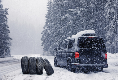 Image of Snow tires near car on road in winter