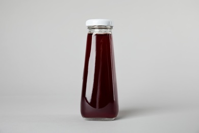 Photo of One bottle with tasty drink on color background